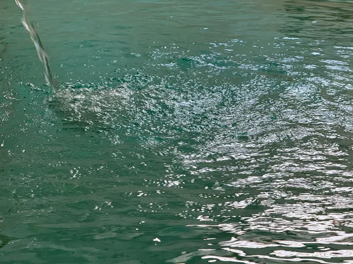 La superficie dell'acqua termale, con il getto che vi cade sopra