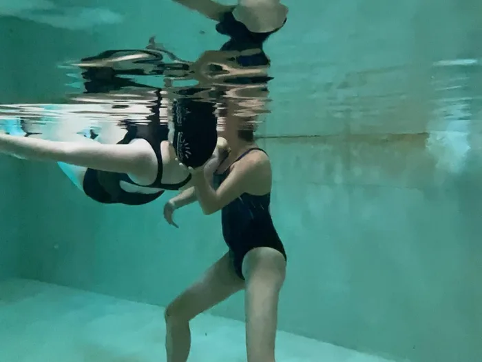 Sesión de fisioterapia acuática: la fisioterapeuta sostiene a la usuaria en la piscina termal