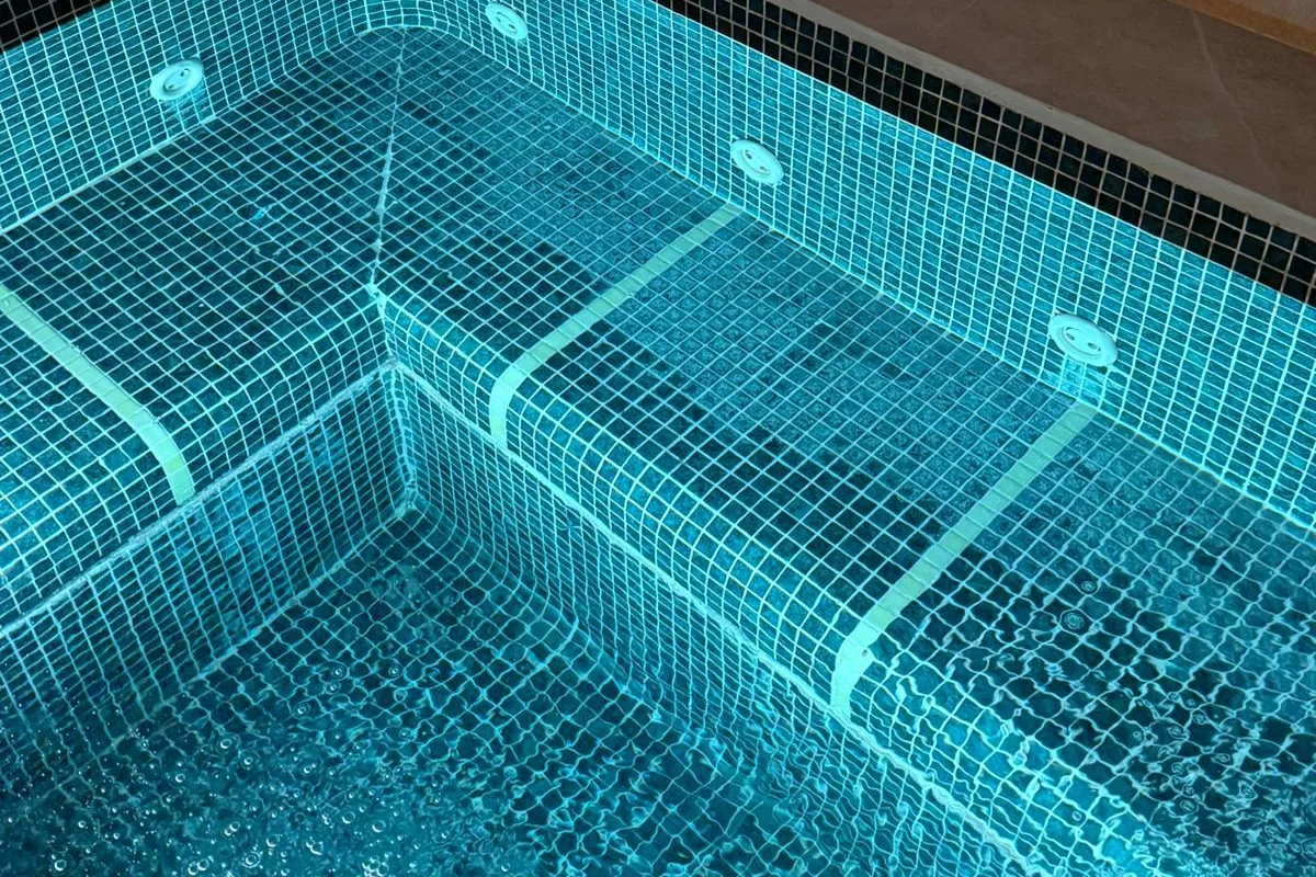 El jacuzzi renovado, con la iluminación encendida bajo el agua