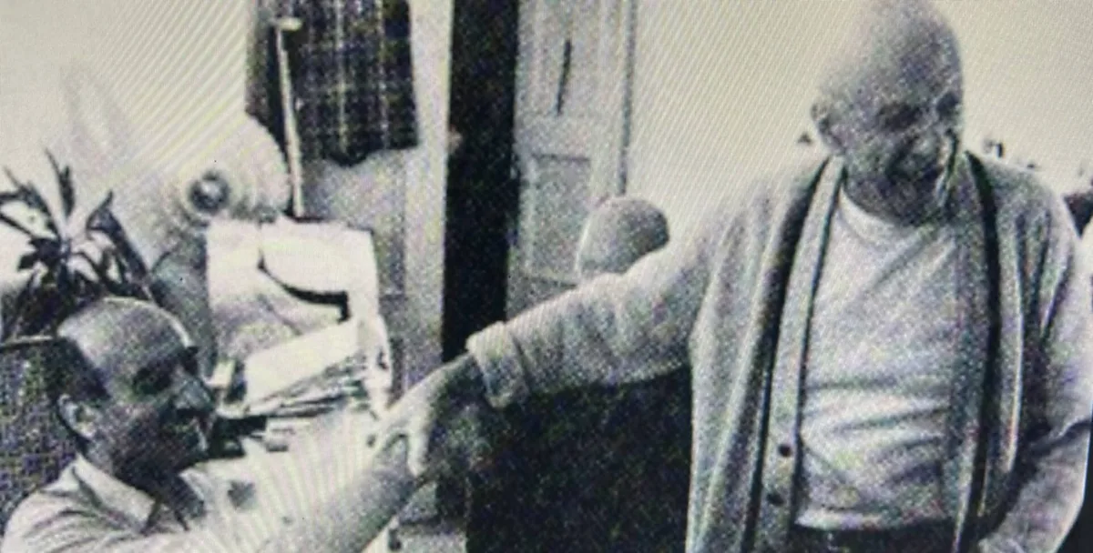 Fotografia storica in bianco e nero di Pablo Picasso mentre conversa in un interno